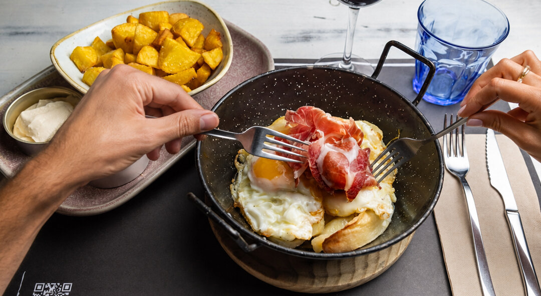 Huevos estrellados con jamón y patatas bravas para compartir en LaPepa Restaurant, eventos y catering en Plaza Europa, Barcelona