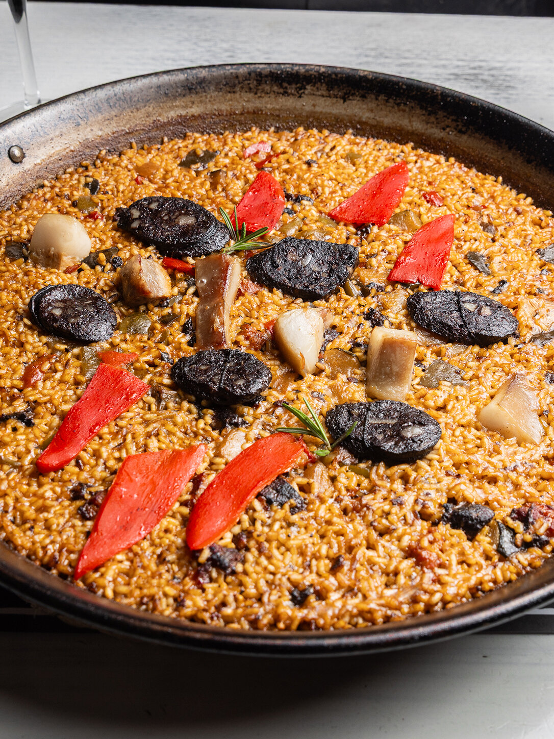 Paella tradicional con morcilla y pimientos asados en LaPepa Restaurant, experiencia gastronómica en Plaza Europa, Barcelona
